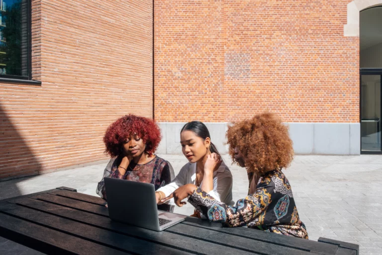 Three women social workers looking at a laptop